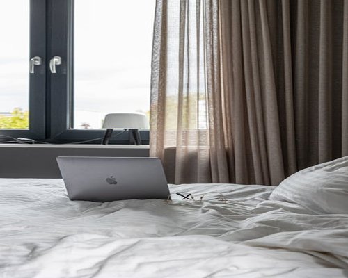 Relaxed laptop placement avoiding sharp workspace glare under protective curtains