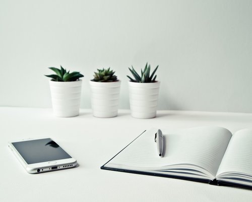 Organized workspace materials with clean smartphone layouts under diffuse studio light