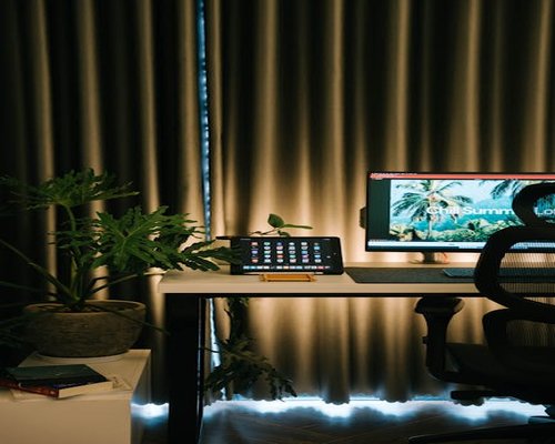Desk setup utilizing ambient light filtering through soft window curtains