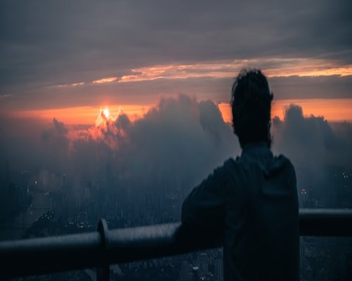 A person taking a moment to look at distant urban landscapes during an office interval